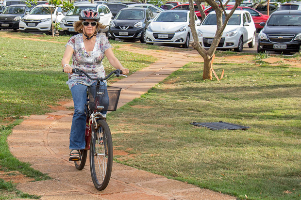 Professora Eloisa anda de bicicleta usando capacete e óculos de sol
