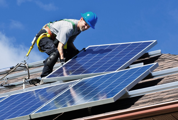 Trabalhador coloca placas de energia solar