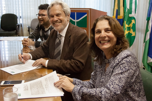 Márcia sorrindo assina acordo com sercretário geral da oea