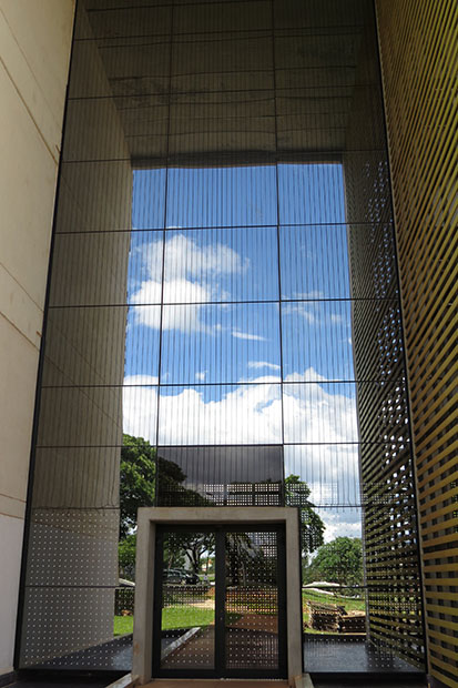 Fachada da portal lateral do Bloco de Salas de Aula Sul foi sinalizada com adesivos na parte inferior e com cordões na parte superior para evitar o choque das aves ocasionado pelo reflexo da paisagem no vidro espelhado. Foto: divulgação do projeto